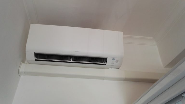 Condizionatore a parete bianco montato in alto.
