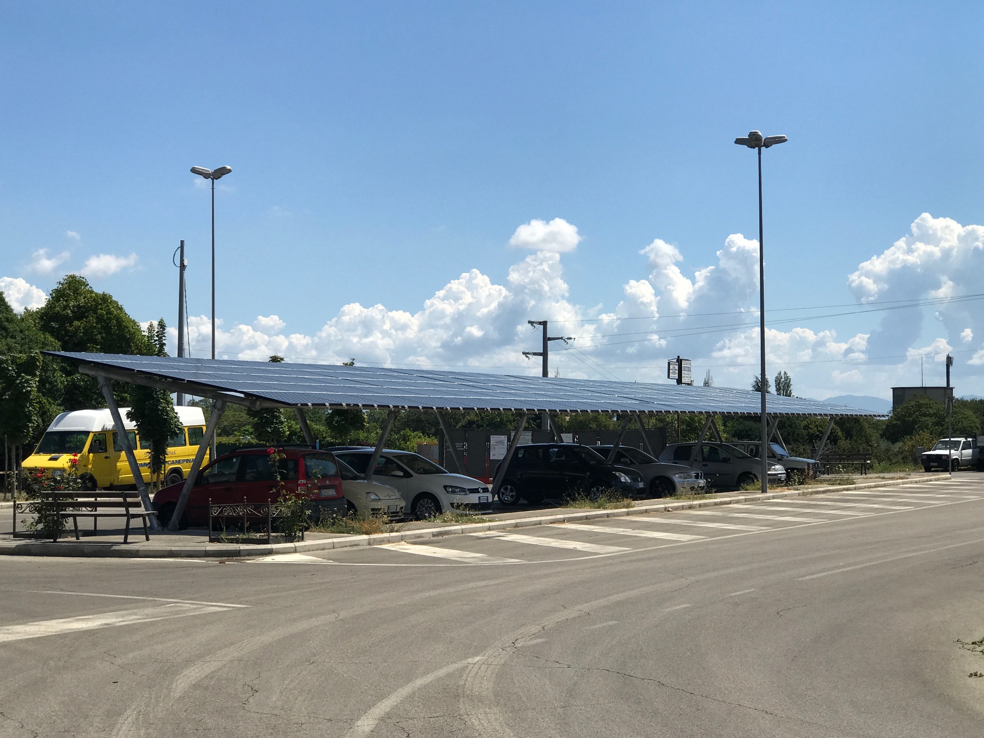 Auto parcheggiate sotto tettoia con pannelli solari.