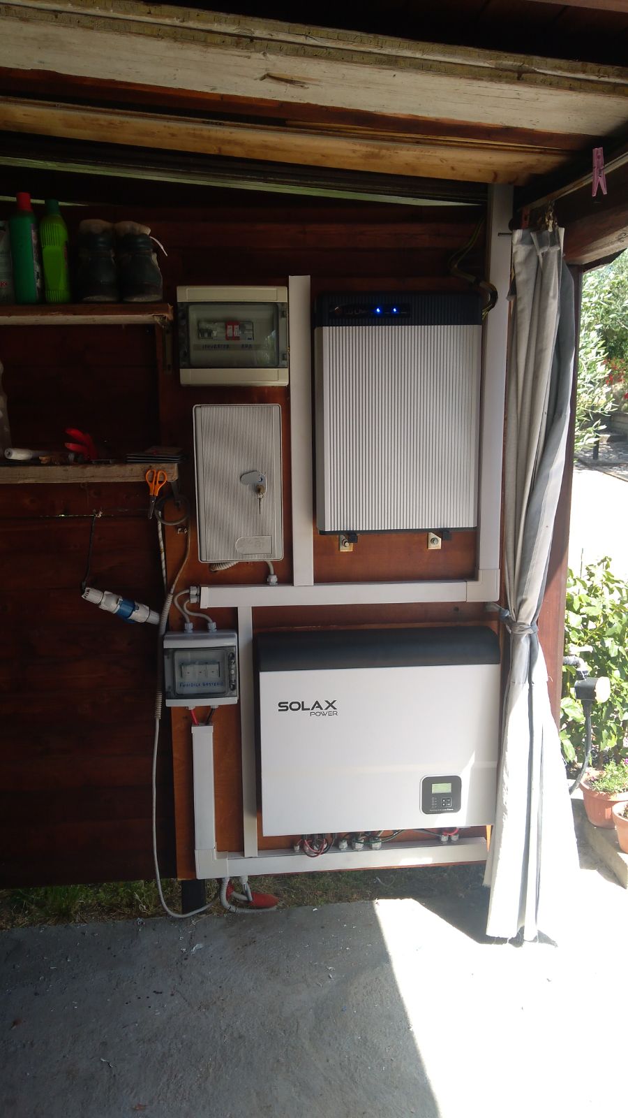 Inverter e attrezzature elettriche montati su parete di legno.