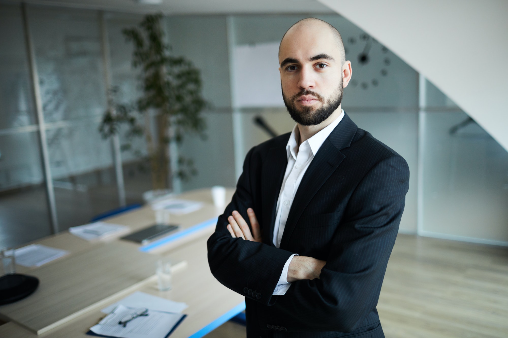 Uomo in giacca e cravatta in ufficio moderno.