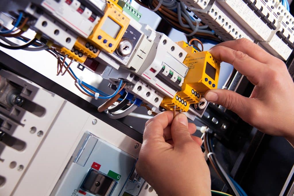 Mani che lavorano su un quadro elettrico.